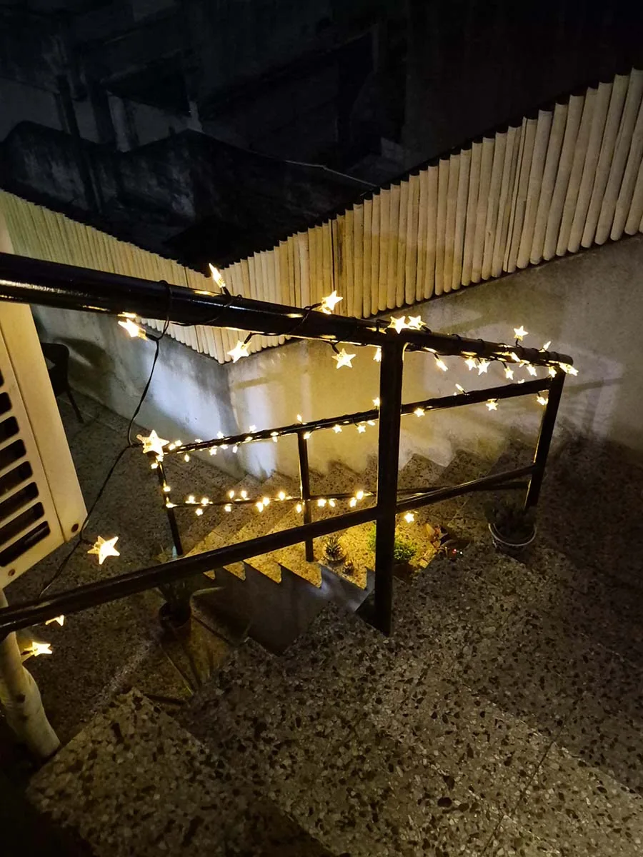 Guirnalda solar de estrellas con luz cálida de 10 metros decorando una escalera y su baranda exterior.
