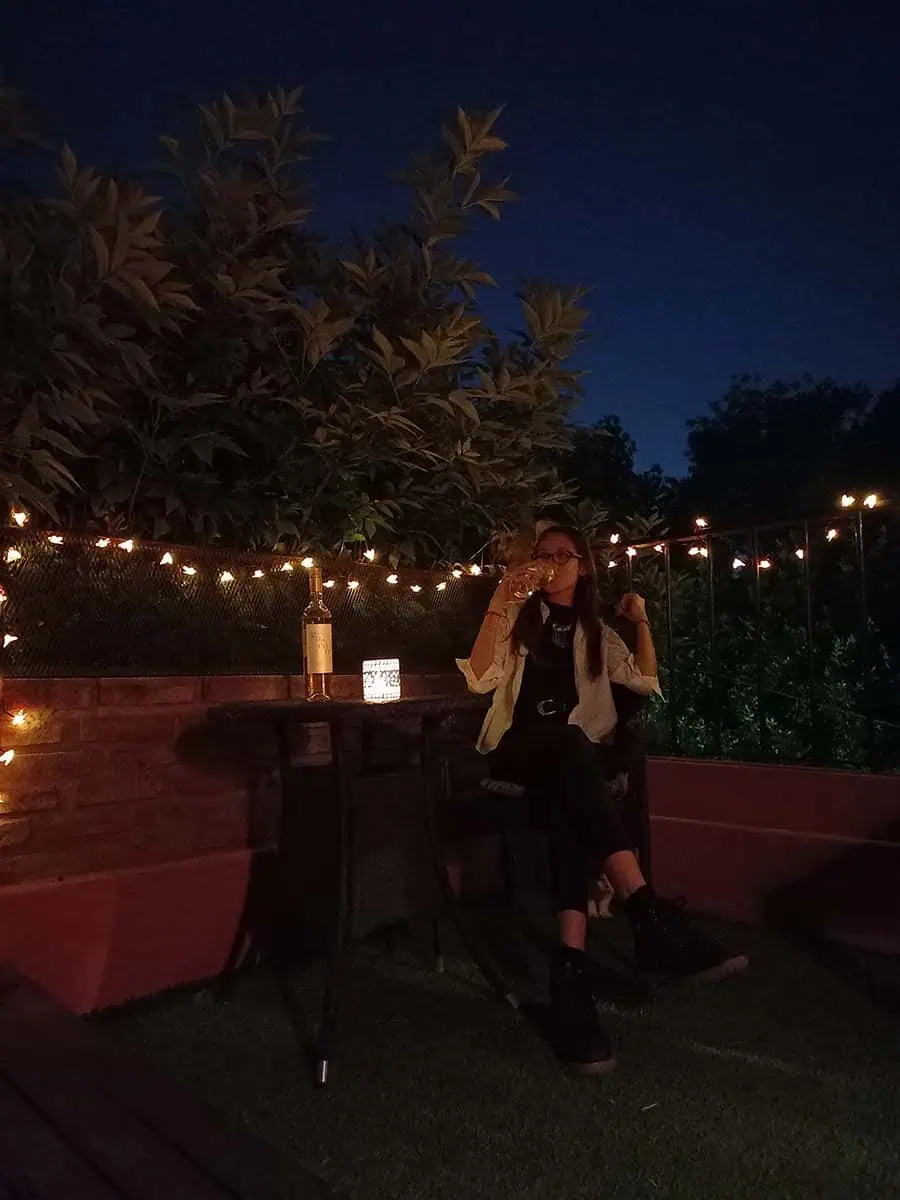 Guirnalda solar de abejitas con luz cálida decorando la baranda y pared de una terraza durante la noche.