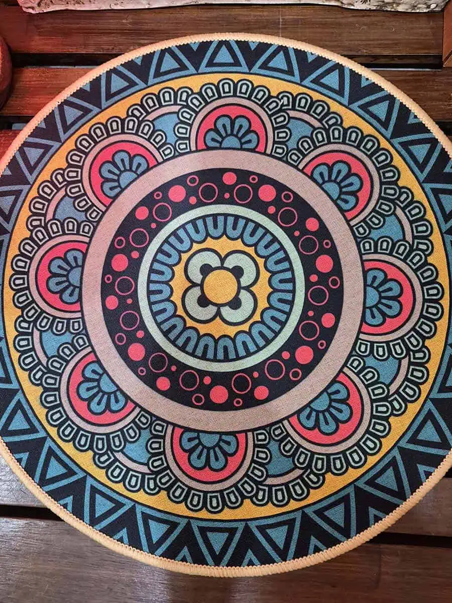Individual redondo con mandala azul, rosa, amarillo y celeste para decorar la mesa