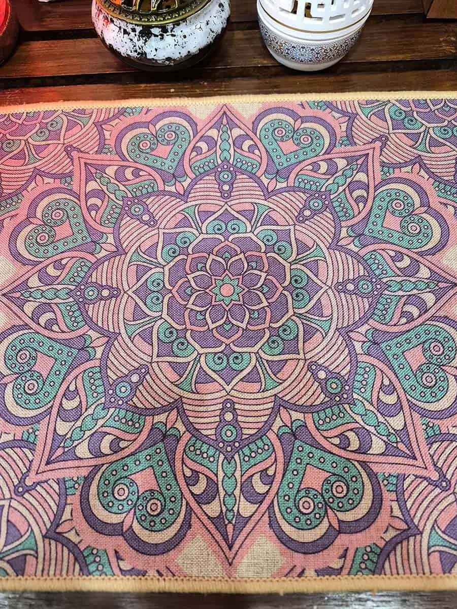Individual rectangular con mandala rosa, verde y violeta de diseño floral