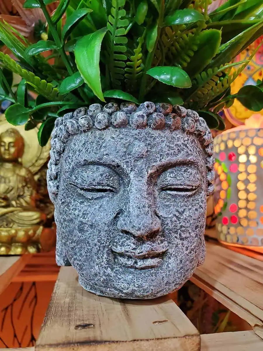 Maceta con cara de Buda con flores bordo artificiales