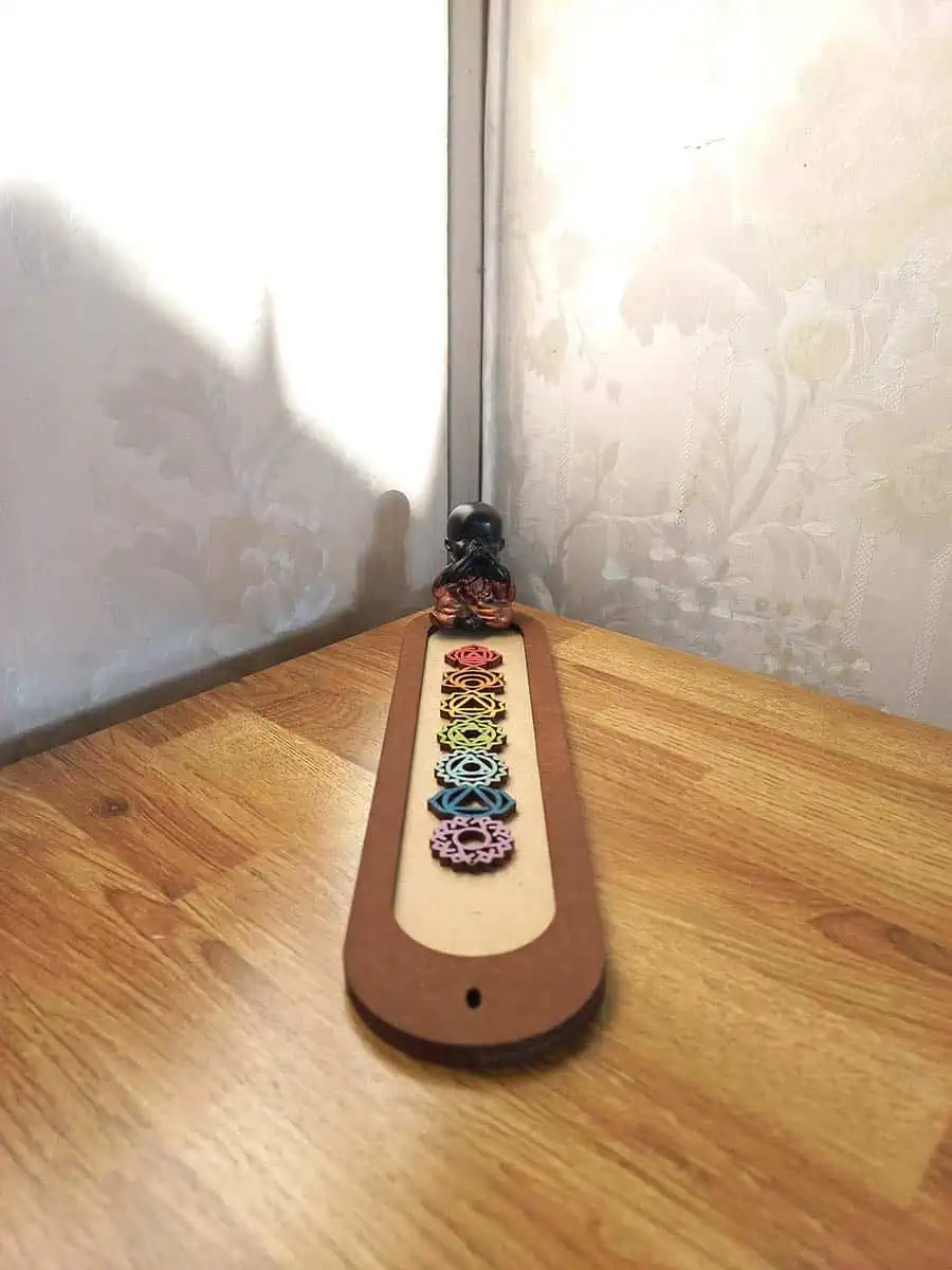 imagen de un portasahumerio de madera lindo con los 7 chakras y un buidta o ganesha