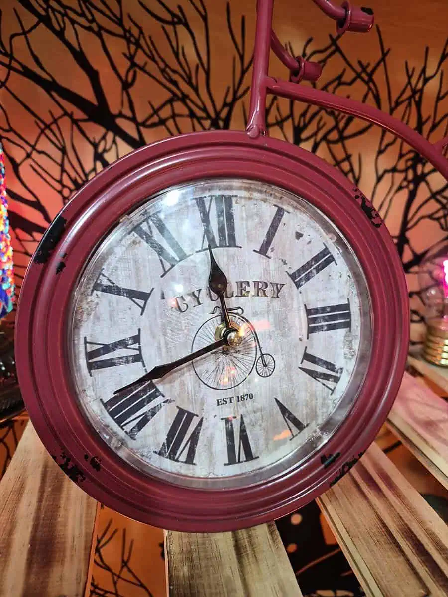 Reloj decorativo vintage bordó con forma de bicicleta antigua y números romanos