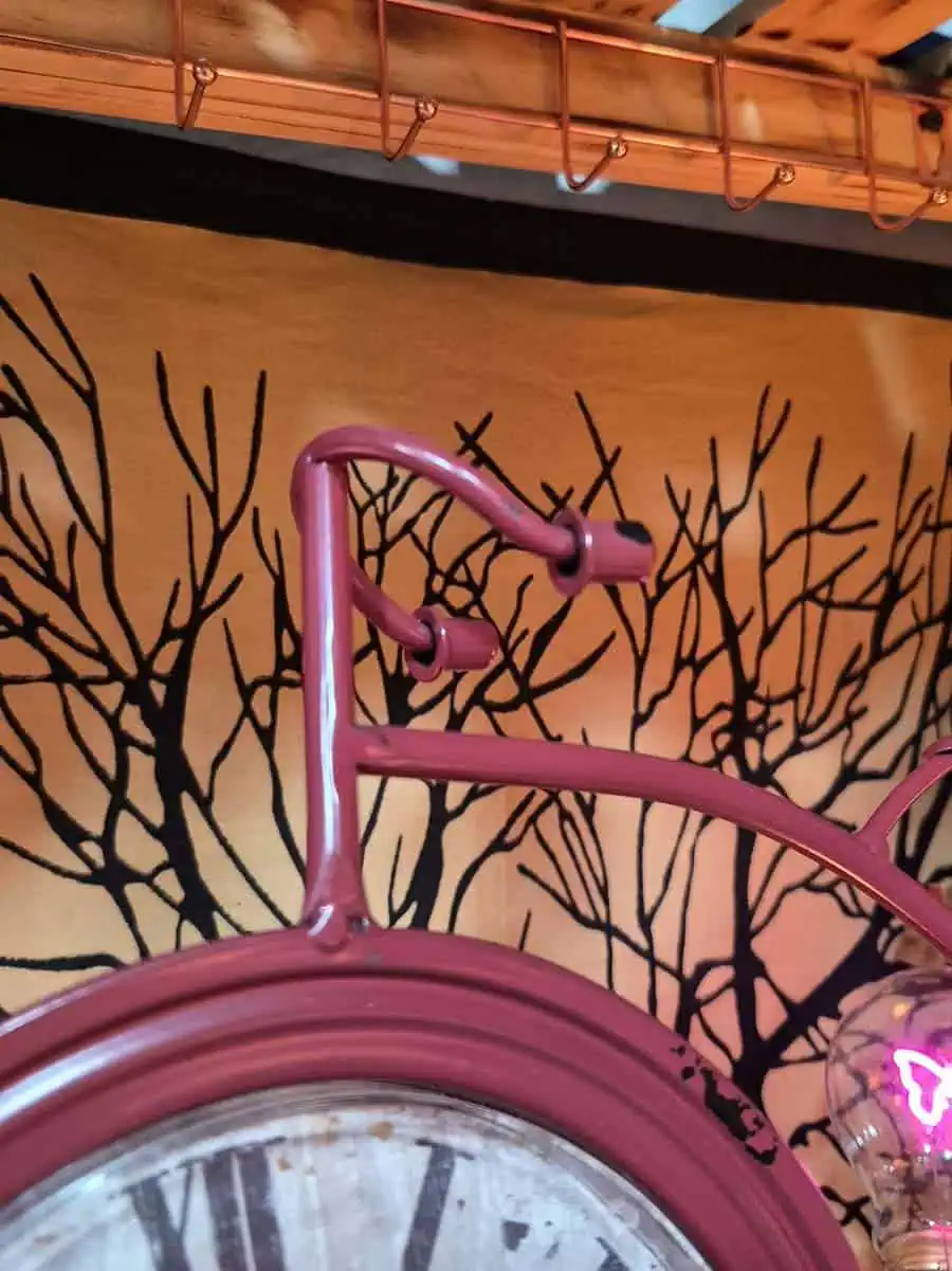Reloj decorativo vintage bordó con forma de bicicleta antigua y números romanos